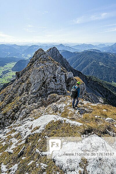 Hiker with climbing helmet  on hiking trail at a ridge  view of mountain landscape  in the back summit of Seehorn  Nuaracher Höhenweg  Loferer Steinberge  Tyrol  Austria  Europe
