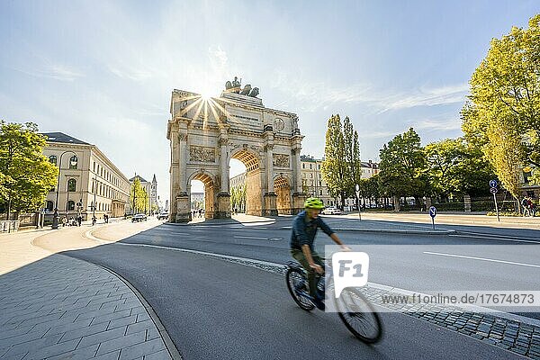 Sonnenstern  Siegestor  Fahrradfahrer fährt an der Leopoldstraße  Neoklassizistische Architektur  Bayern  München  Bayern  Deutschland  Europa