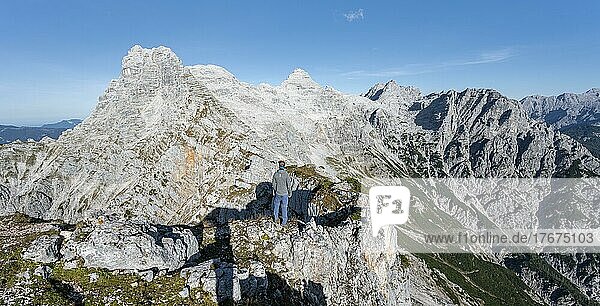 Hiker at the summit of Seehorn  hiking trail along a ridge  view of mountain landscape  in the background mountain ridge with peaks Schaflegg and Mitterhorn  Nuaracher Höhenweg  Loferer Steinberge  Tyrol  Austria  Europe