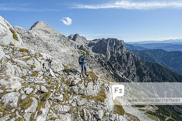 Wanderer mit Kletterhelm  auf Wanderweg  Ausblick auf Berglandschaft  hinten Gipfel des Mitterhorn  Nuaracher Höhenweg  Loferer Steinberge  Tirol  Österreich  Europa