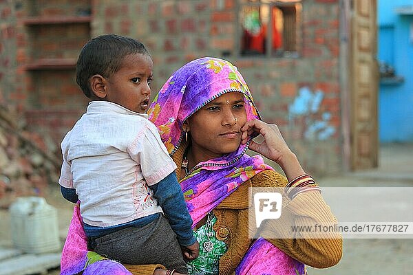 Nordindien  Rajasthan  junge Frau mit Tuch auf dem Kopf und ihrem kleinen Jungen auf dem Arm  Indien  Asien