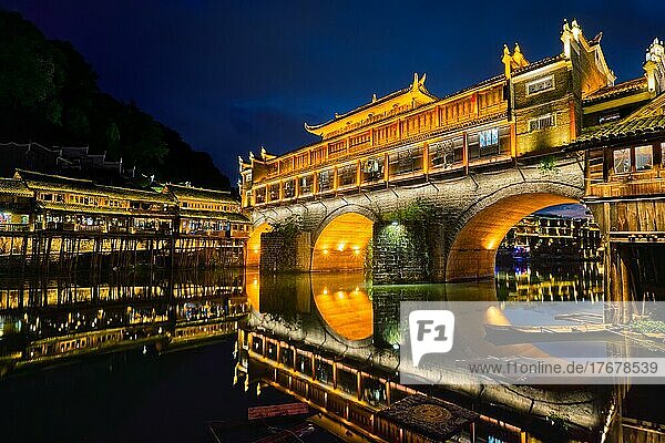 Chinesische Touristenattraktion  die alte Stadt Feng Huang (alte Stadt des Phönix) am Fluss Tuo Jiang bei Nacht beleuchtet. Provinz Hunan  China  Asien