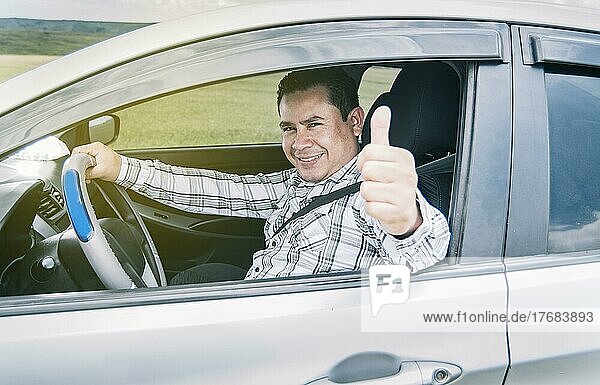 Glücklicher Mann in seinem Auto  der die Daumen nach oben streckt  Porträt eines Mannes  der beim Fahren die Daumen nach oben streckt  Mann in seinem Auto