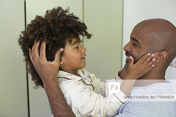 Daughter touching his father's face and looking at each other