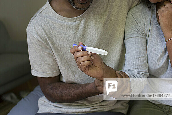 Close up of a woman's hand holding a pregnancy test kit