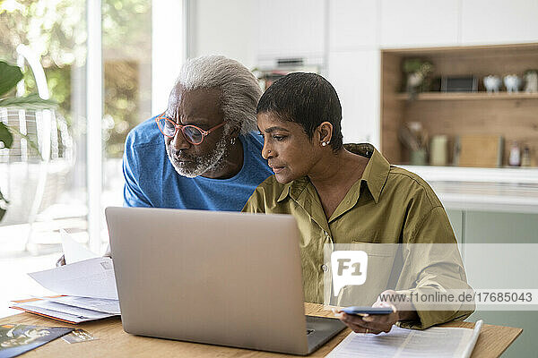 Couple checking documents in kitchen