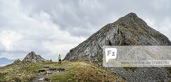 Senior woman standing at mountain peak