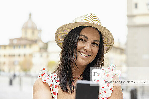 Happy woman with mobile phone taking selfie