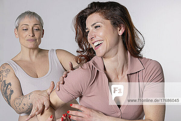 Happy redhead woman with friend having fun against white background