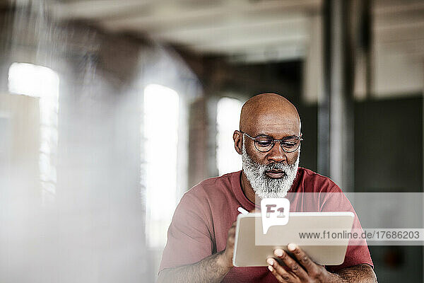 Man with beard using tablet PC at home
