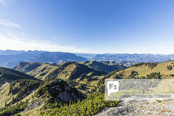 Germany  Bavaria  Female hiker admiring view of Chiemgau Alps on way to Geigelstein mountain