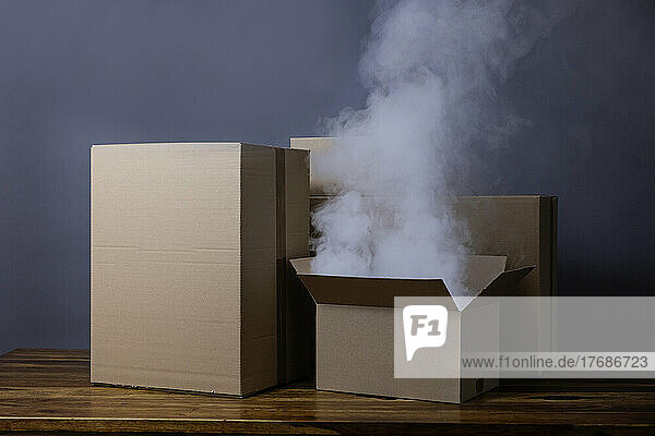 Studio shot of smoke rising from open cardboard box