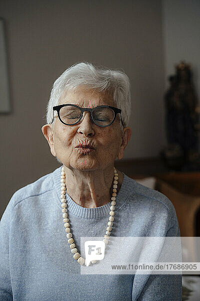 Senior woman with puckering face at home