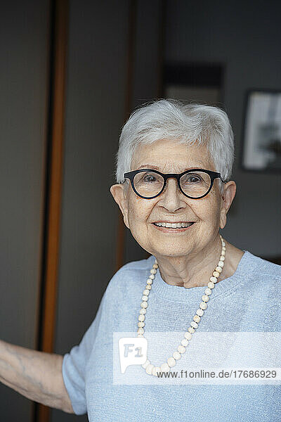 Smiling senior woman with white hair in apartment