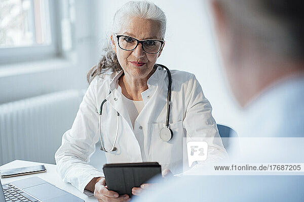 Doctor wearing eyeglasses discussing with patient