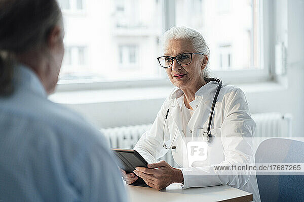Doctor discussing with patient sitting at desk