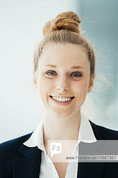 Happy businesswoman with hair bun at office