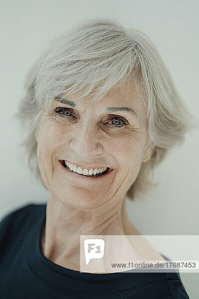 Smiling senior woman against white background