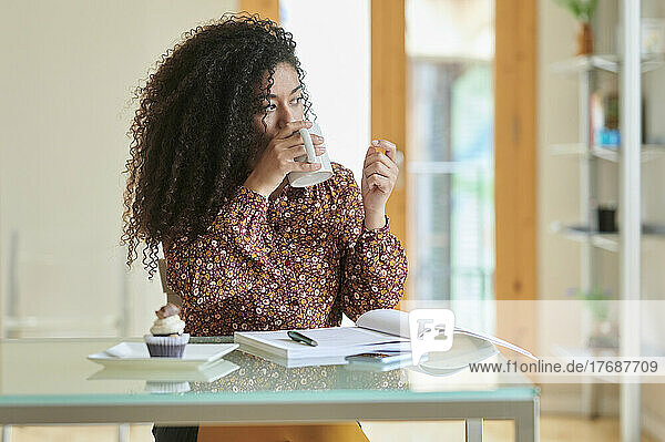 Young businesswoman drinking coffee at home