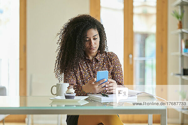 Young businesswoman using mobile phone at home