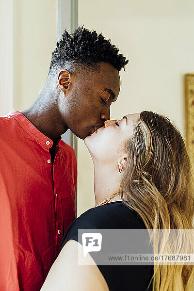 Couple with closed eyes kissing each other at home