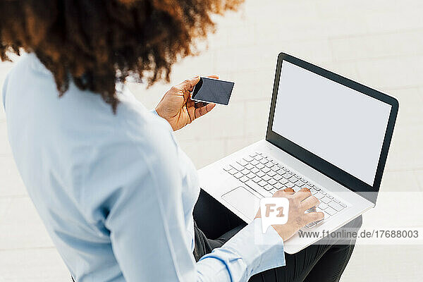 Businesswoman holding credit card using laptop for online shopping