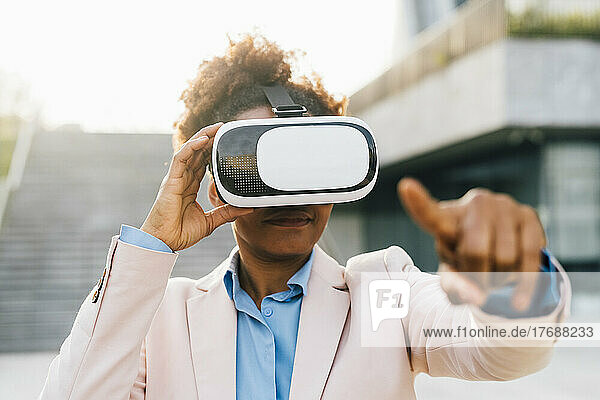 Businesswoman wearing virtual reality simulator and gesturing