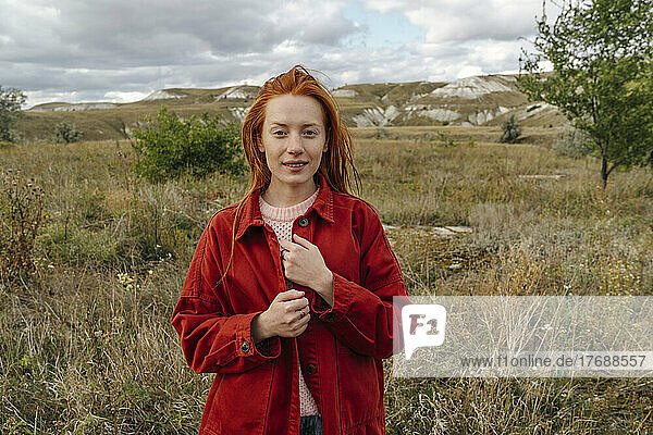 Redhead young woman standing in grass field