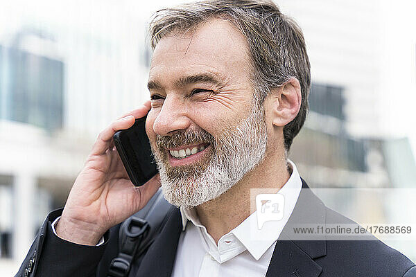 Happy mature businessman talking on mobile phone
