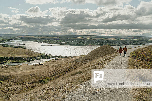 Couple walking on dirt road by Volga river