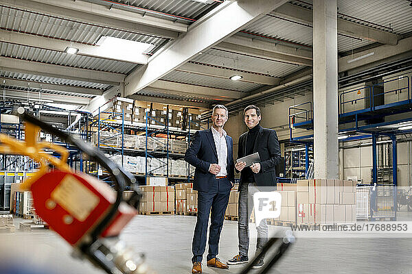 Smiling business people in businesswear at warehouse