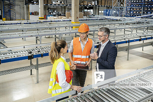 Businessman discussing with colleagues in warehouse