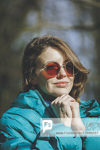Young beautiful woman with brown hair wearing sunglasses on sunny day