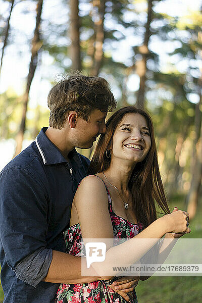 Young man with happy girlfriend in forest