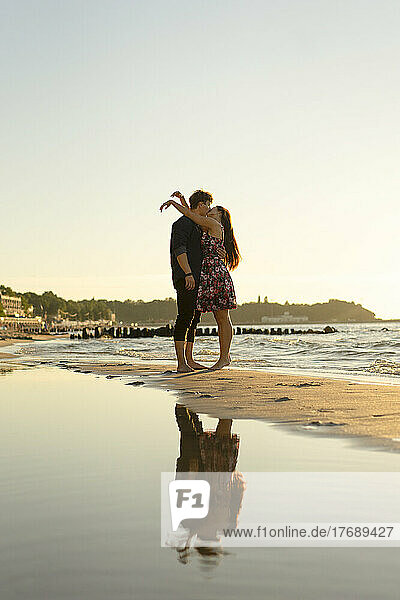 Zärtliches junges Paar  das sich am Strand küsst