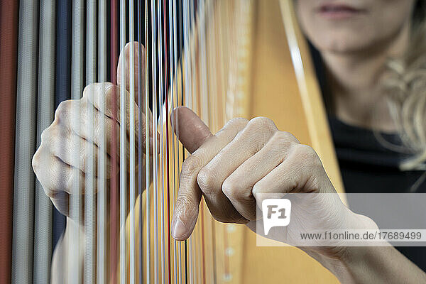 Hands of mature woman playing harp