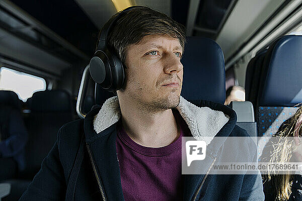 Man wearing headphones traveling in train