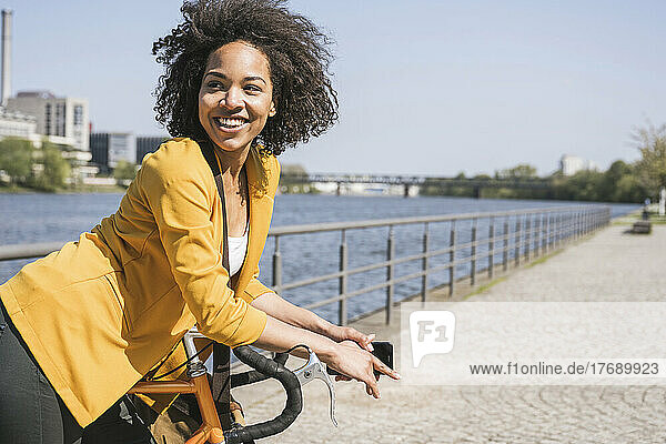 Nachdenkliche Geschäftsfrau  die sich auf das Fahrrad stützt