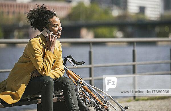 Young businesswoman talking on smart phone on sunny day
