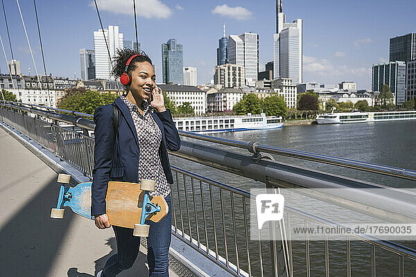 Businesswoman listening music through headphones by River Main