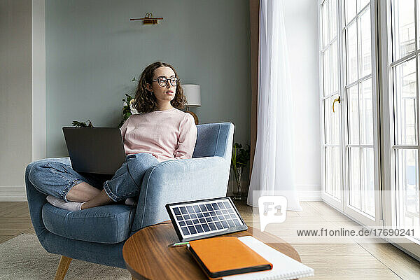 Young freelancer with laptop sitting at home