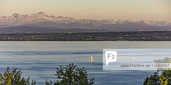 Germany  Baden-Wurttemberg  Meersburg  Panoramic view of sailboats in Lake Constance at dusk with mountains in background
