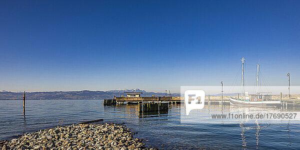 Germany  Baden-Wurttemberg  Langenargen  Clear blue sky over pier on shore of Lake Constance