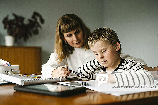 Mother teaching son with disability during homeschooling at home