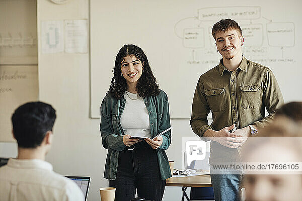 Porträt eines lächelnden männlichen und weiblichen Universitätsstudenten im Klassenzimmer