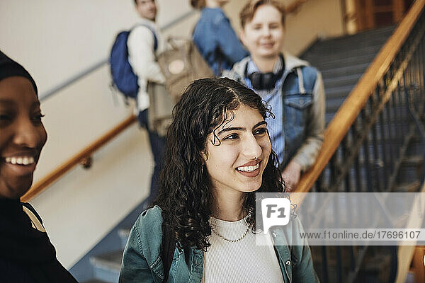 Lächelnde Studentinnen blicken auf eine Treppe in einer Universität