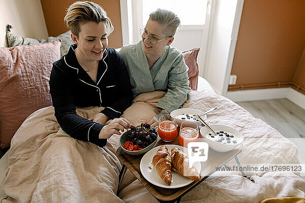 Lesbisches Paar genießt das Frühstück im Bett zu Hause