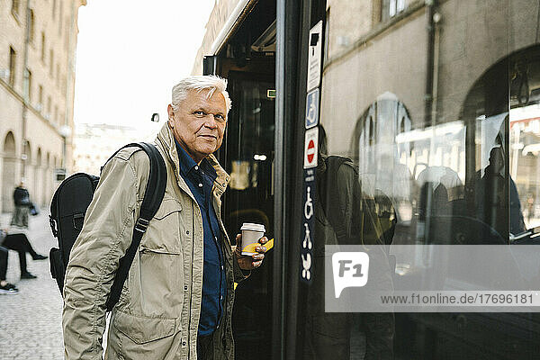 Senior businessman contemplating while boarding in bus