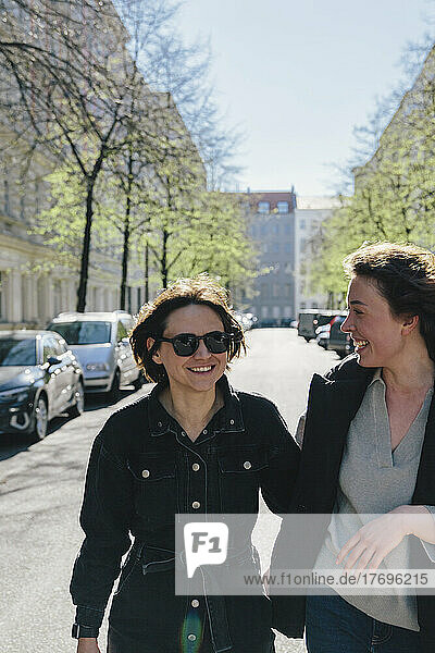 Fröhliches lesbisches Paar auf der Straße in der Stadt an einem sonnigen Tag