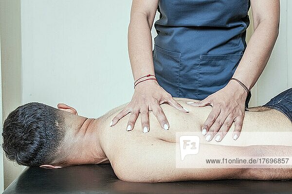 Mann bei chiropraktischer Anpassung des Rückens. Physiotherapeut bei der Behandlung von Wirbelsäulenproblemen eines Patienten  Rehabilitation von Sportverletzungen